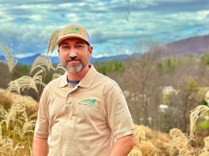 Josh Crowder of WNC Climate Control in his work polo with Blue Ridge Mountains behind him