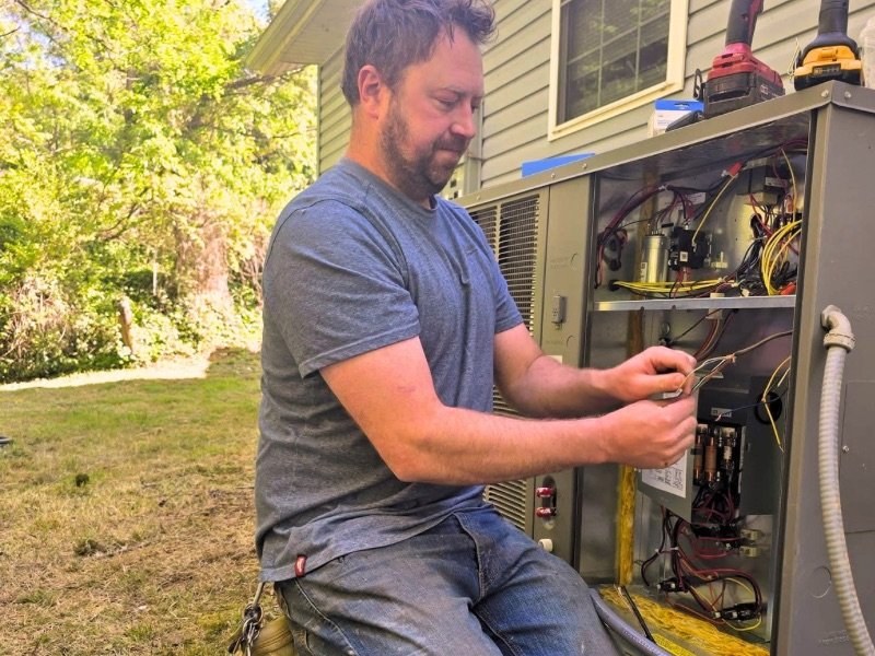 HVAC technician repairing a residential heating and air conditioning system during a same-day service call