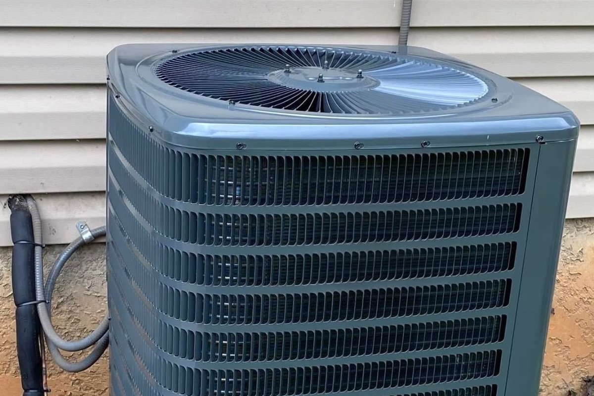 Outdoor AC condenser unit installed beside a home