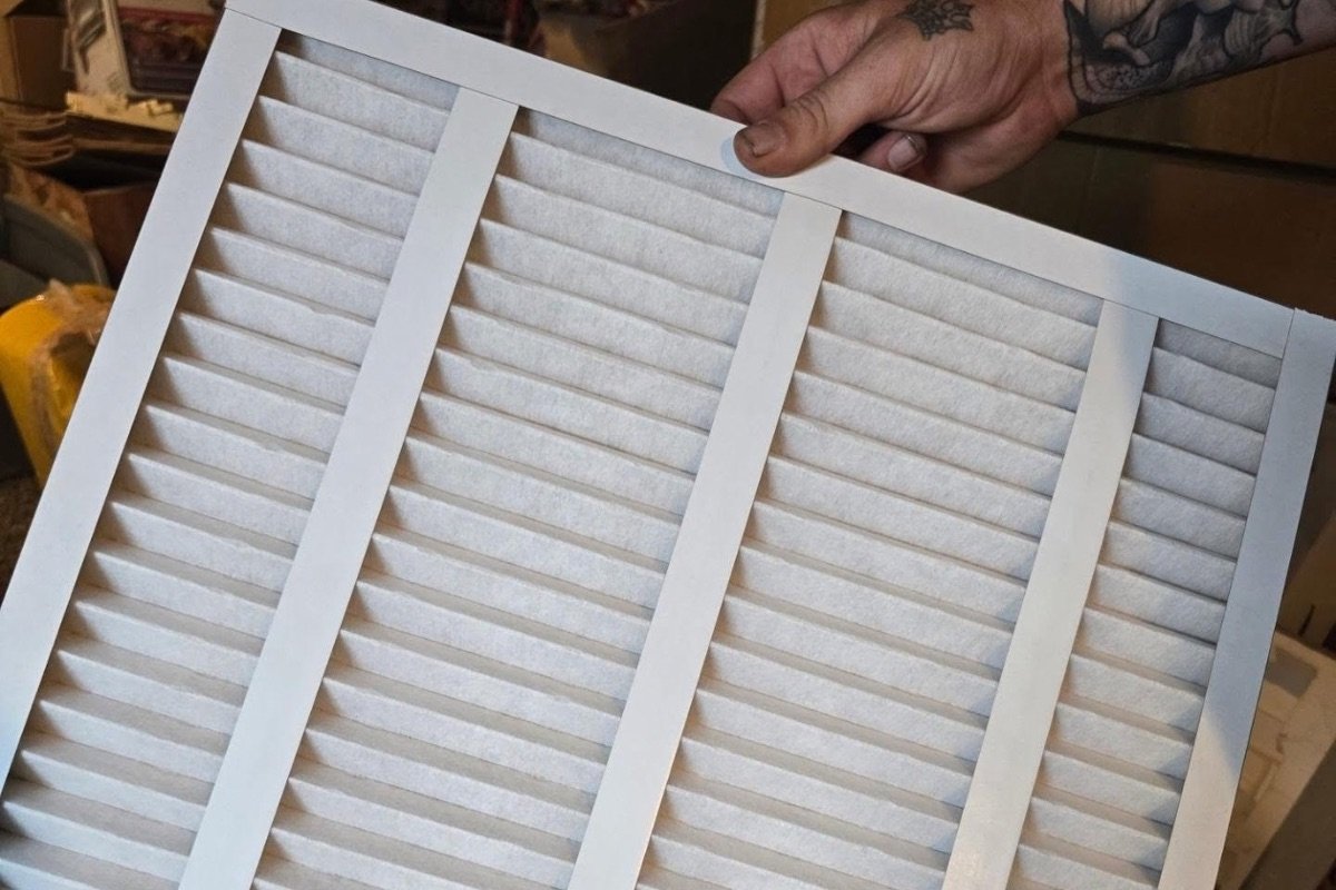 Technician holding a pleated air filter