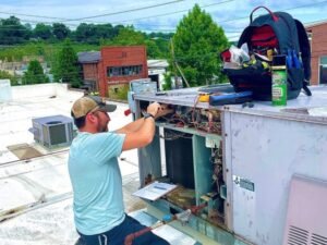 Josh Crowder repairing a commercial rooftop HVAC unit in Asheville, NC