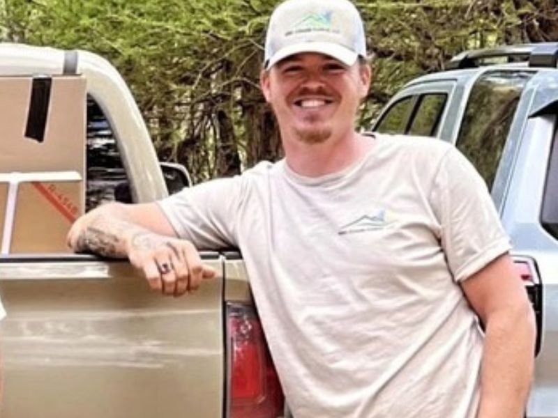 Tony Dotson, HVAC technician at WNC Climate Control, leaning on a tan work truck