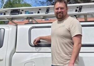 Chris Kuchar, HVAC installer at WNC Climate Control beside white work truck