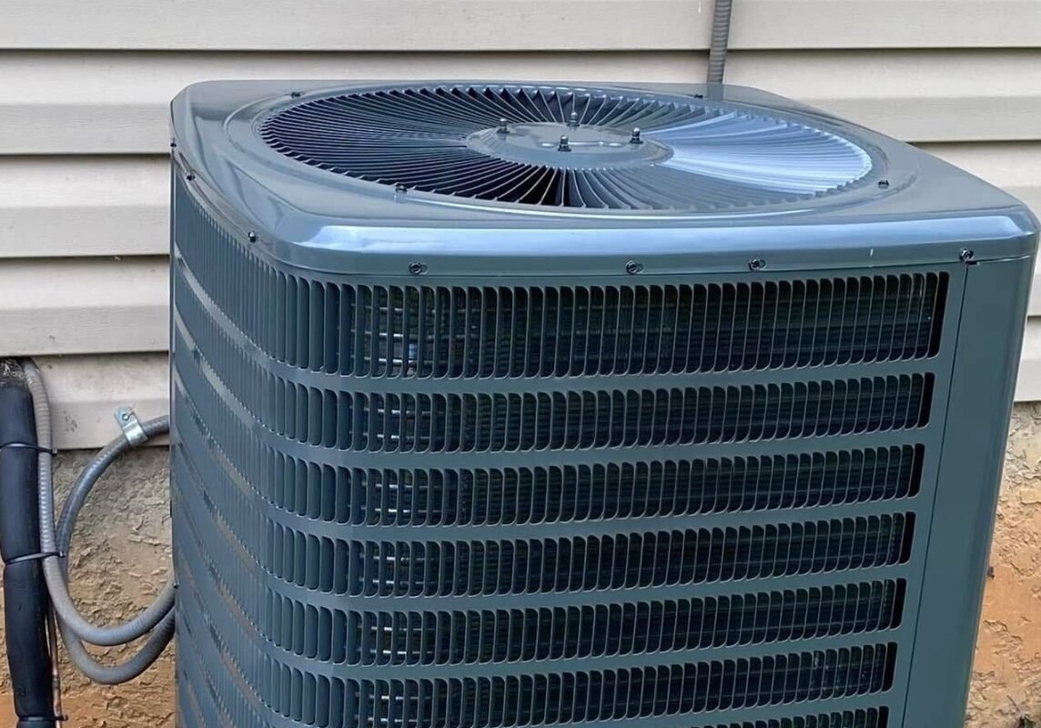 Outdoor air conditioning condenser unit installed beside a home