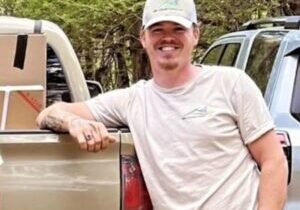 Tony Dotson, HVAC technician at WNC Climate Control, leaning on a tan work truck