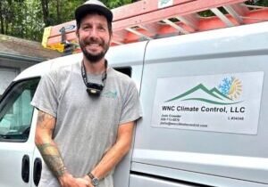 Zak Kay, service and maintenance manager at WNC Climate Control, beside a company van in Weaverville, NC